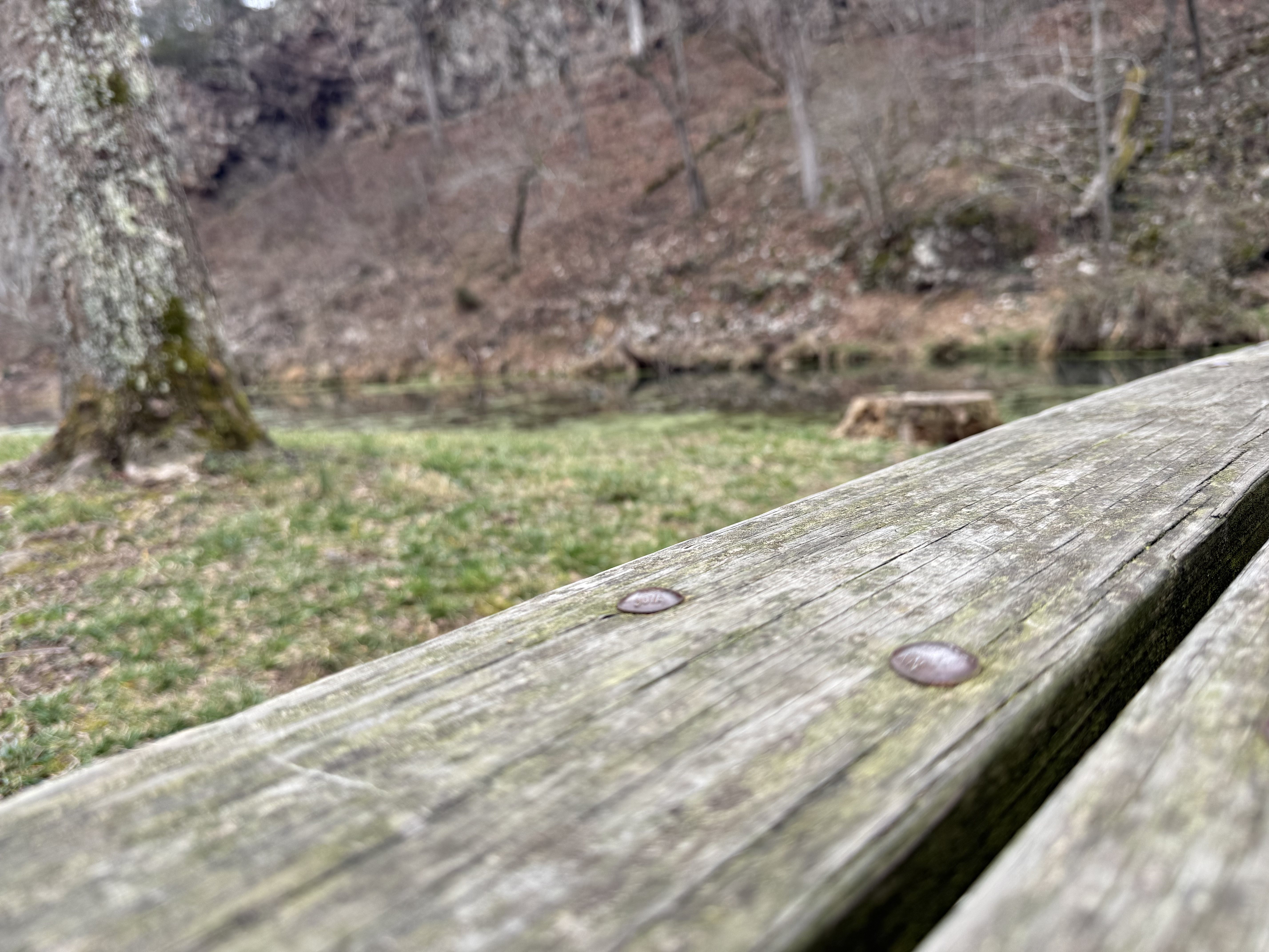 Weathered picnic table at the campsite with creek in background